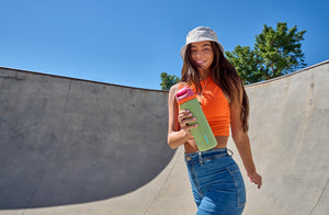 Girl walking and smiling and holding an Owala water bottle